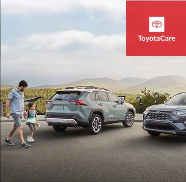 Man walking his son to their Toyota vehicle.
